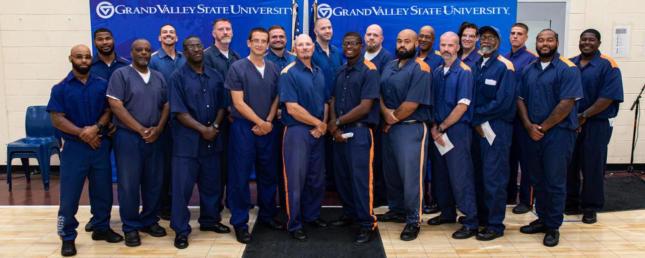Students standing in front of GVSU backdrop